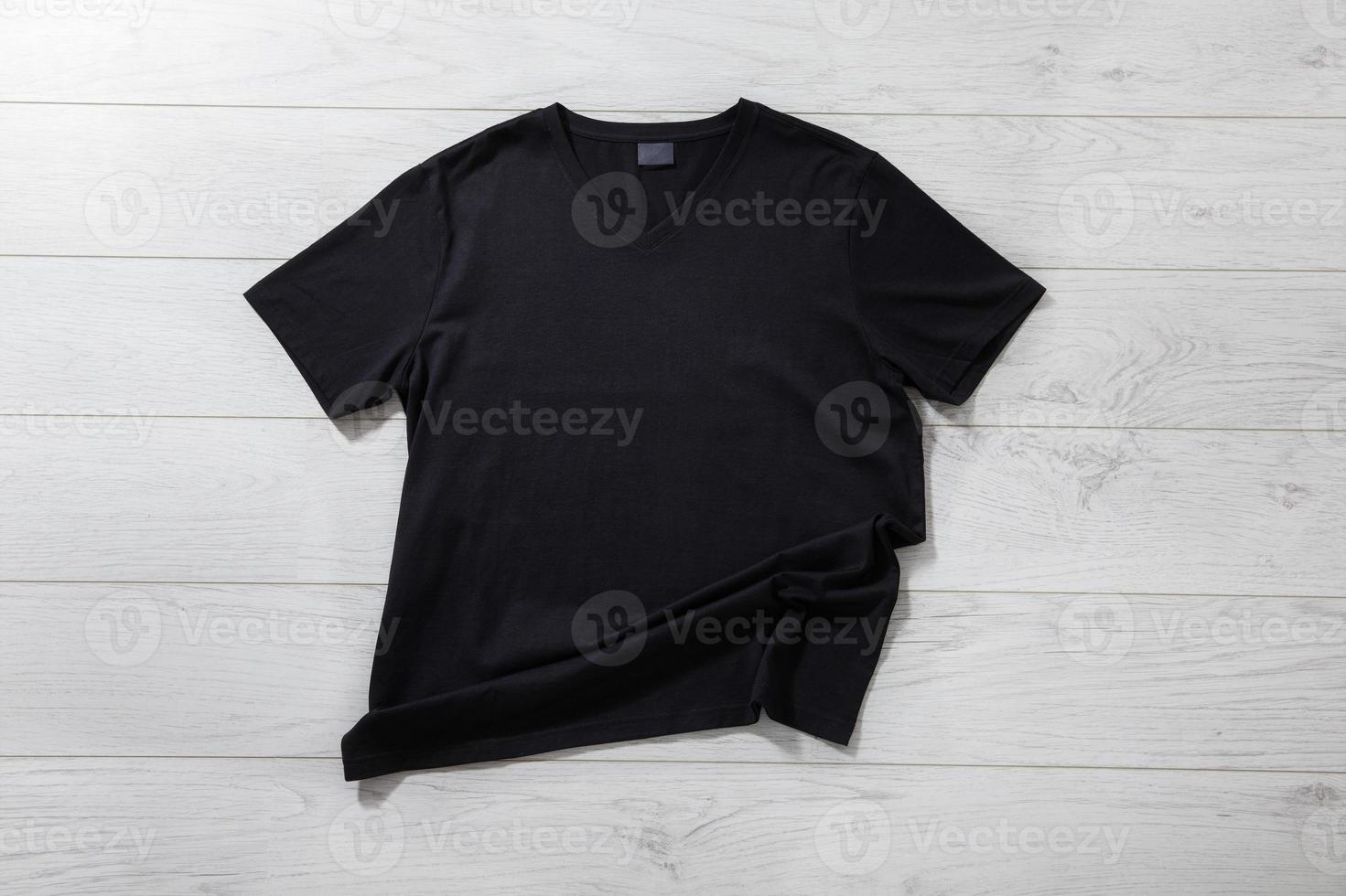 Front views t-shirt on white wooden desk background. Mockup for design closeup photo