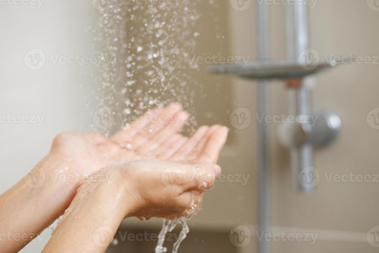 A woman uses hand to measure the water temperature from a water heater