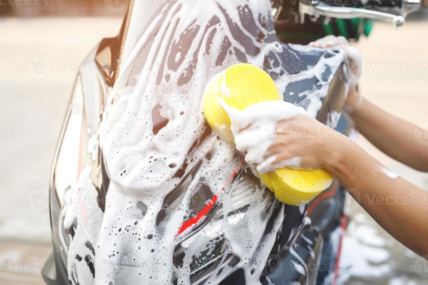 The worker is washing the motorcycle at Car Care. photo