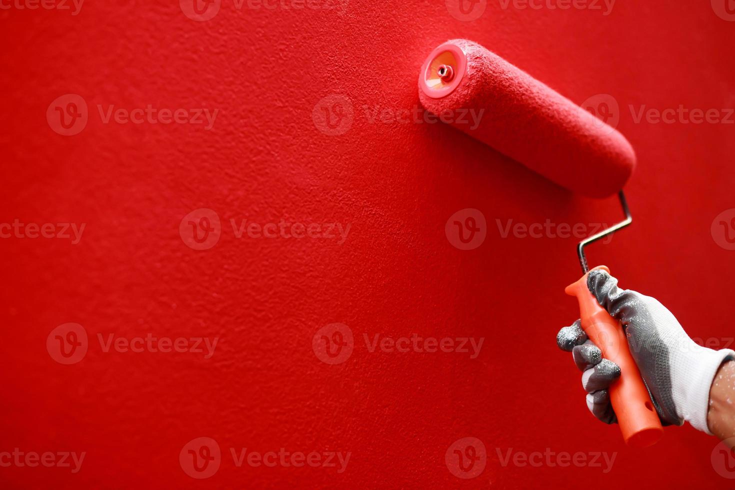 Painter is painting the interior wall red photo