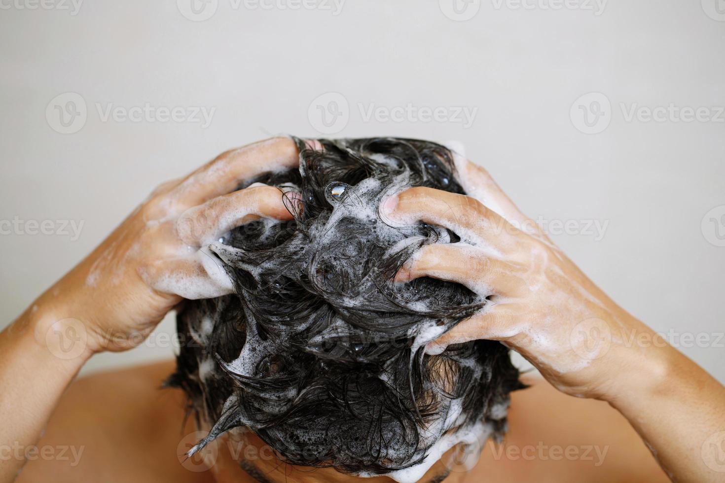 un hombre es Lavado su pelo con champú foto