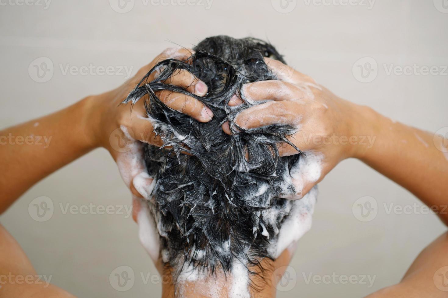 A man is washing his hair with shampoo photo