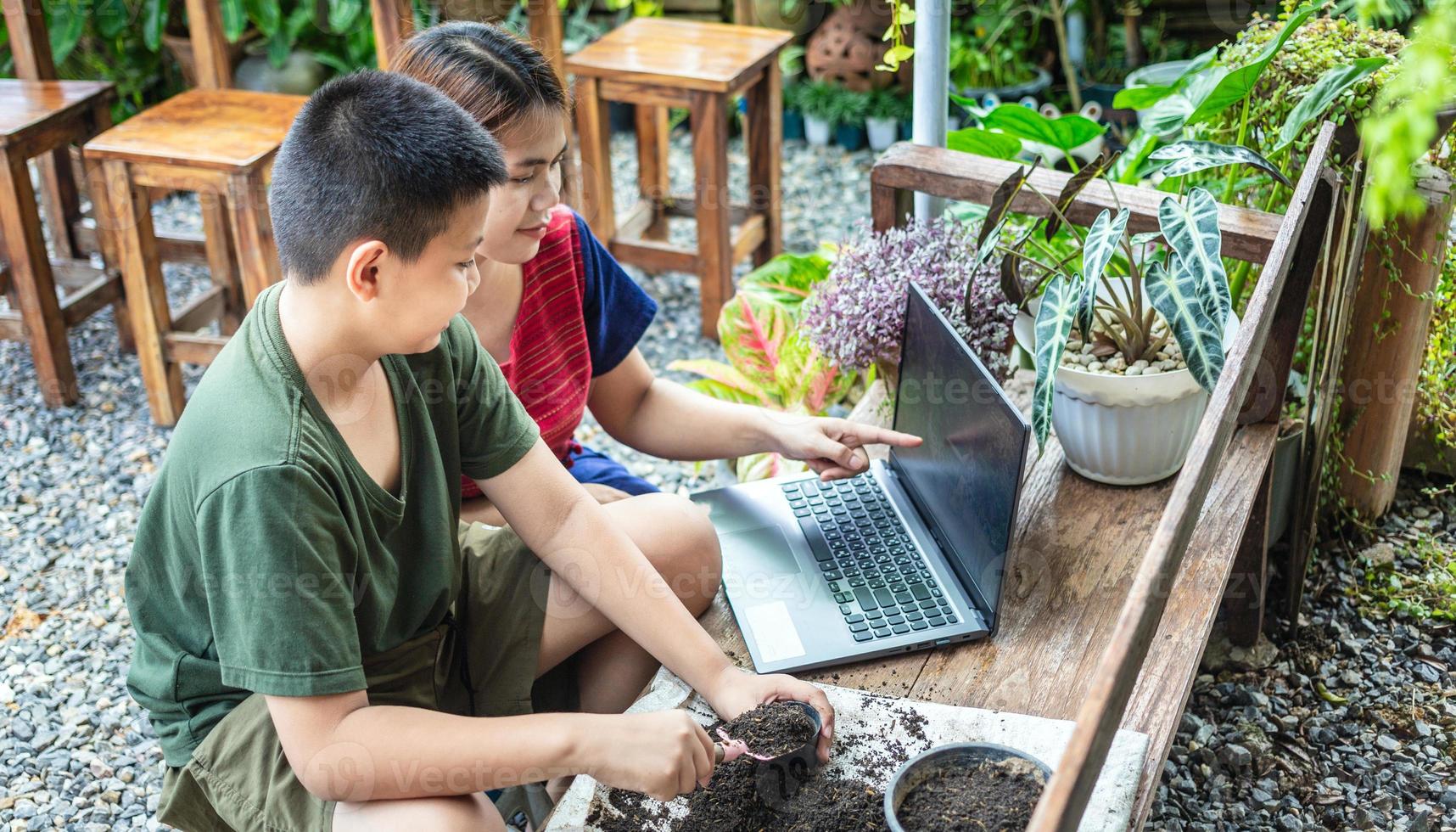 Portrait of a mother and son  special moment. Gardening discovering and teaching learns to grow flowers in pots through online teaching leisure activity concept photo