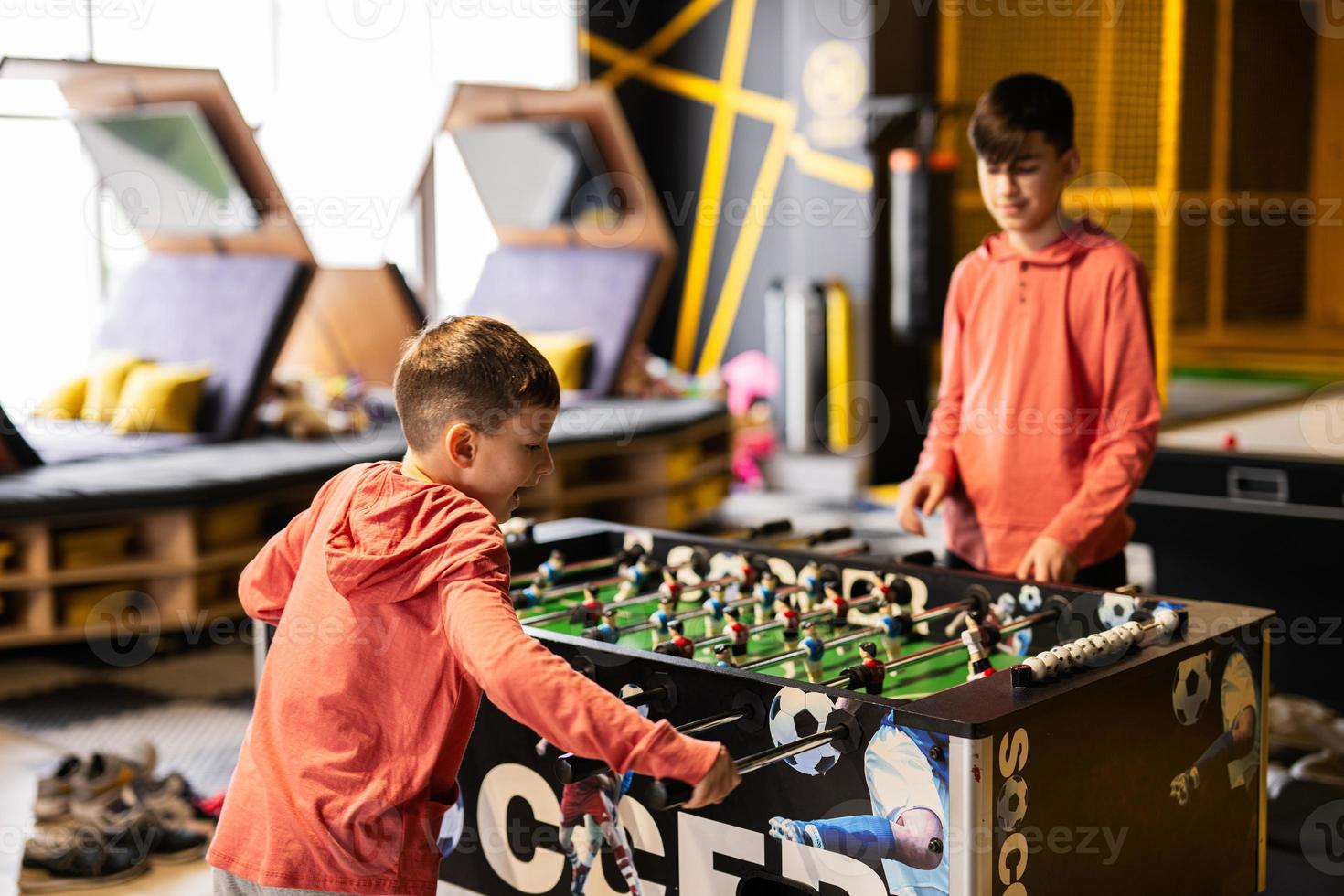 hermanos jugando mesa fútbol americano en niños jugar centro. foto