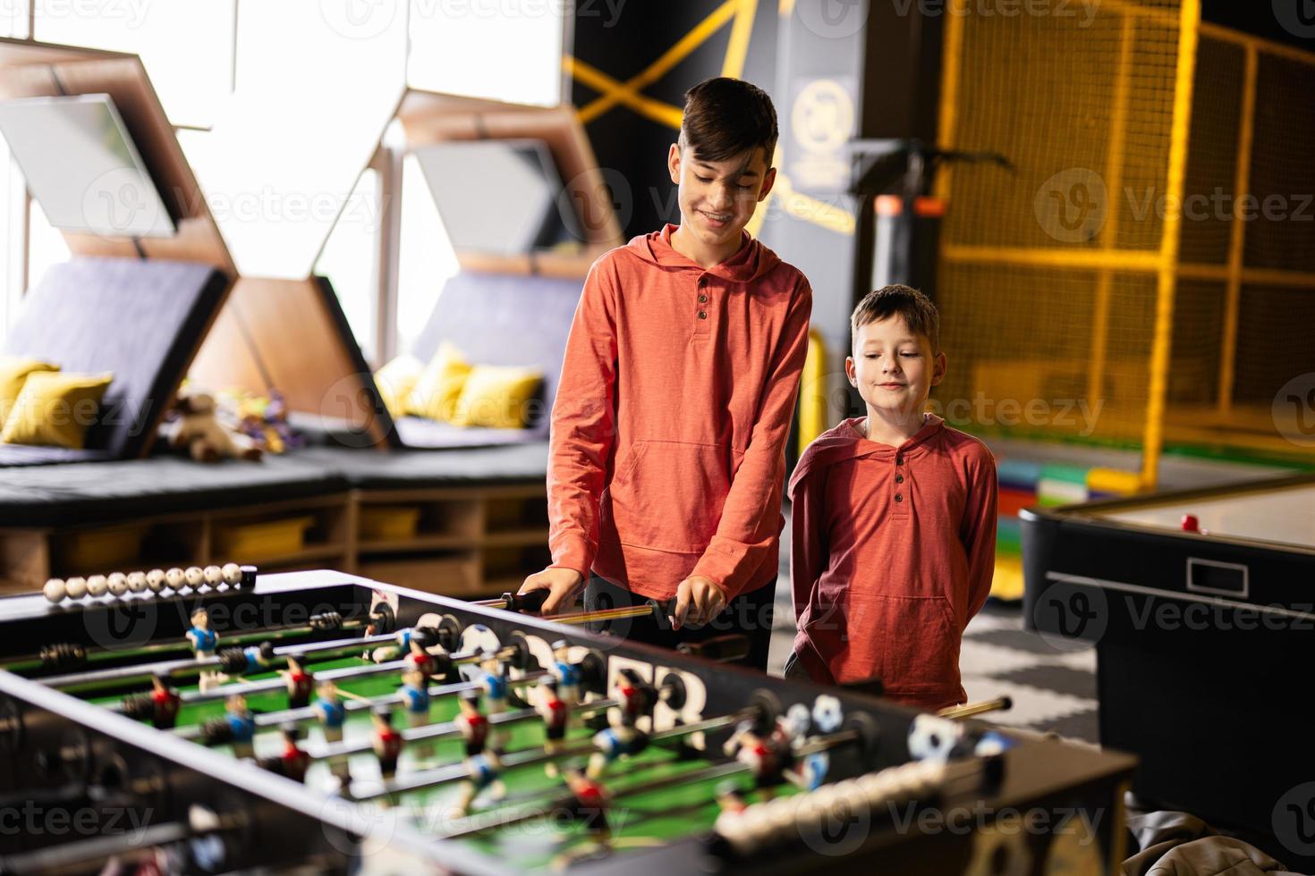 Brothers playing table football in kids play center. photo