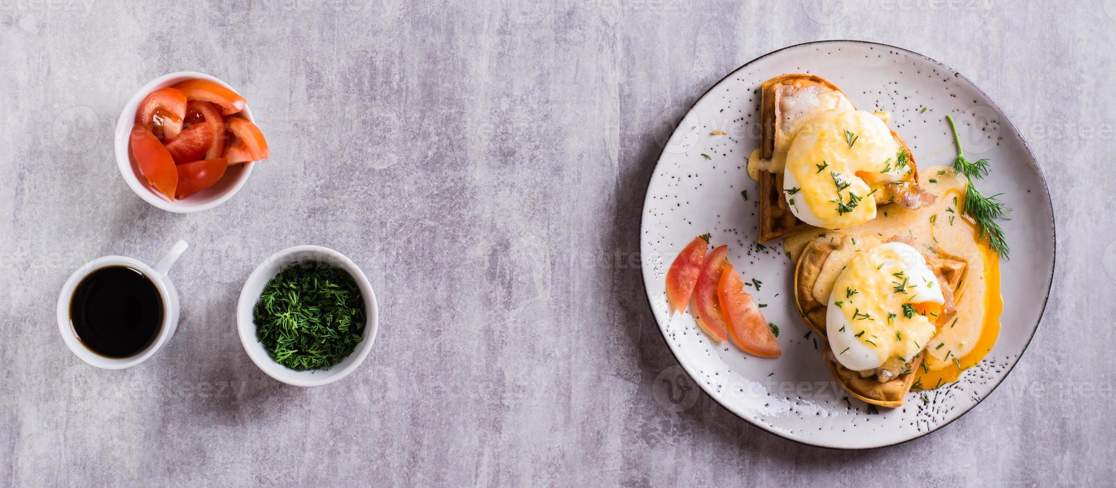 Homemade breakfast with waffles, bacon and eggs benedict on a plate. Top view. Web banner photo