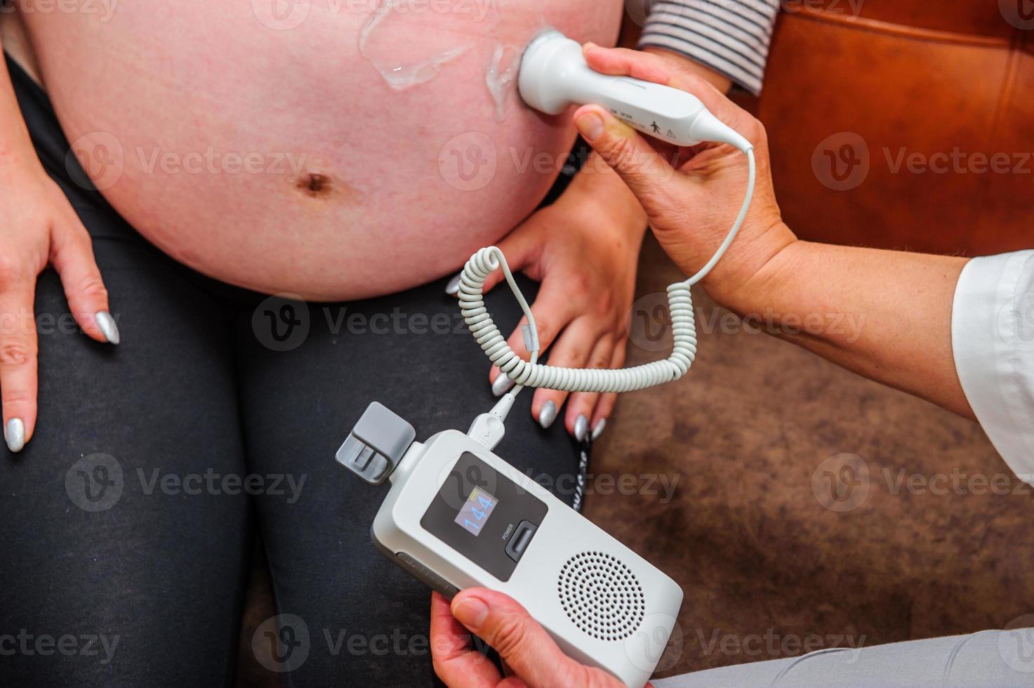 Pregnant woman getting ultrasound from doctor. photo