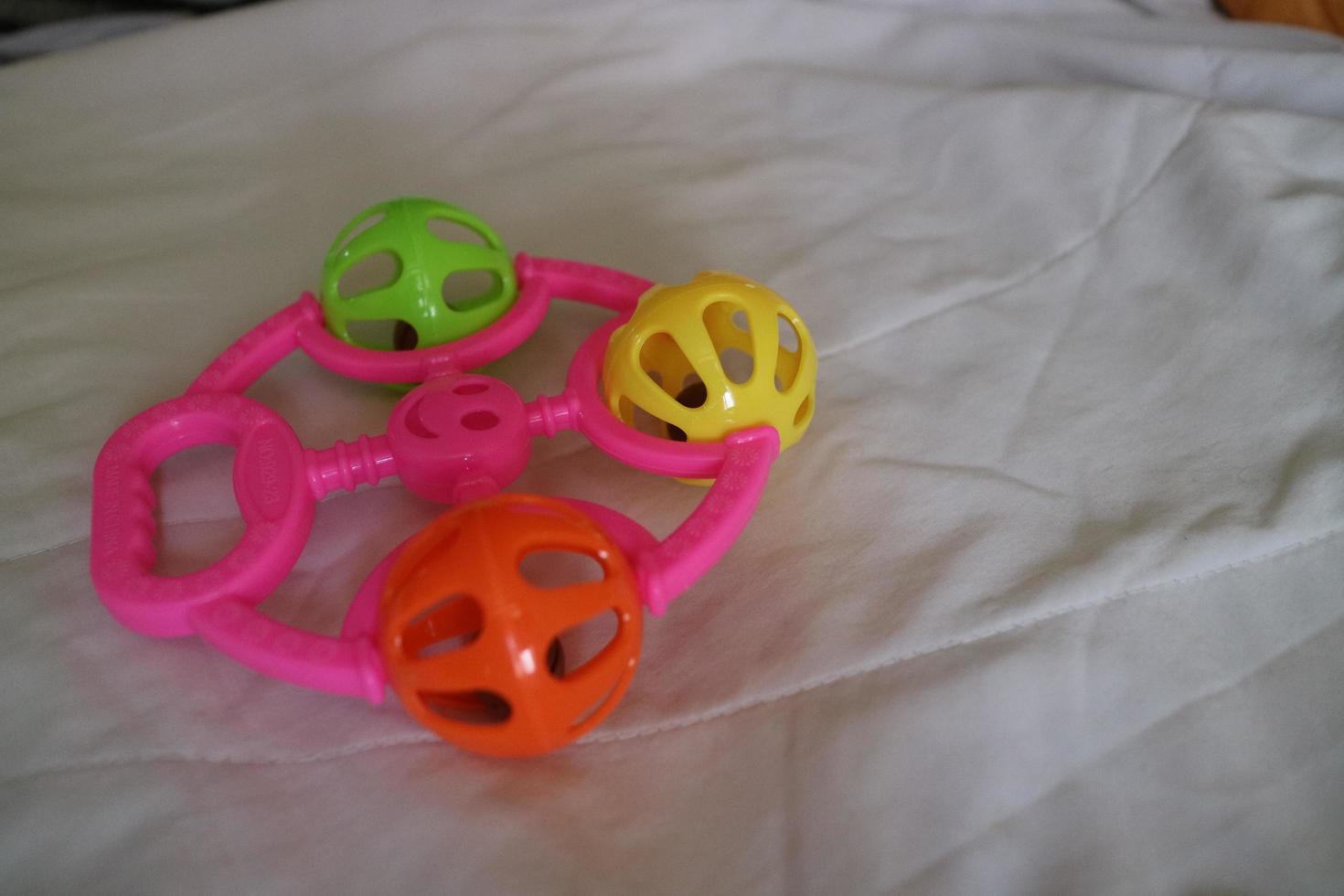 a colorful toddler toy that can make a tinkling sound with a pink handle photo