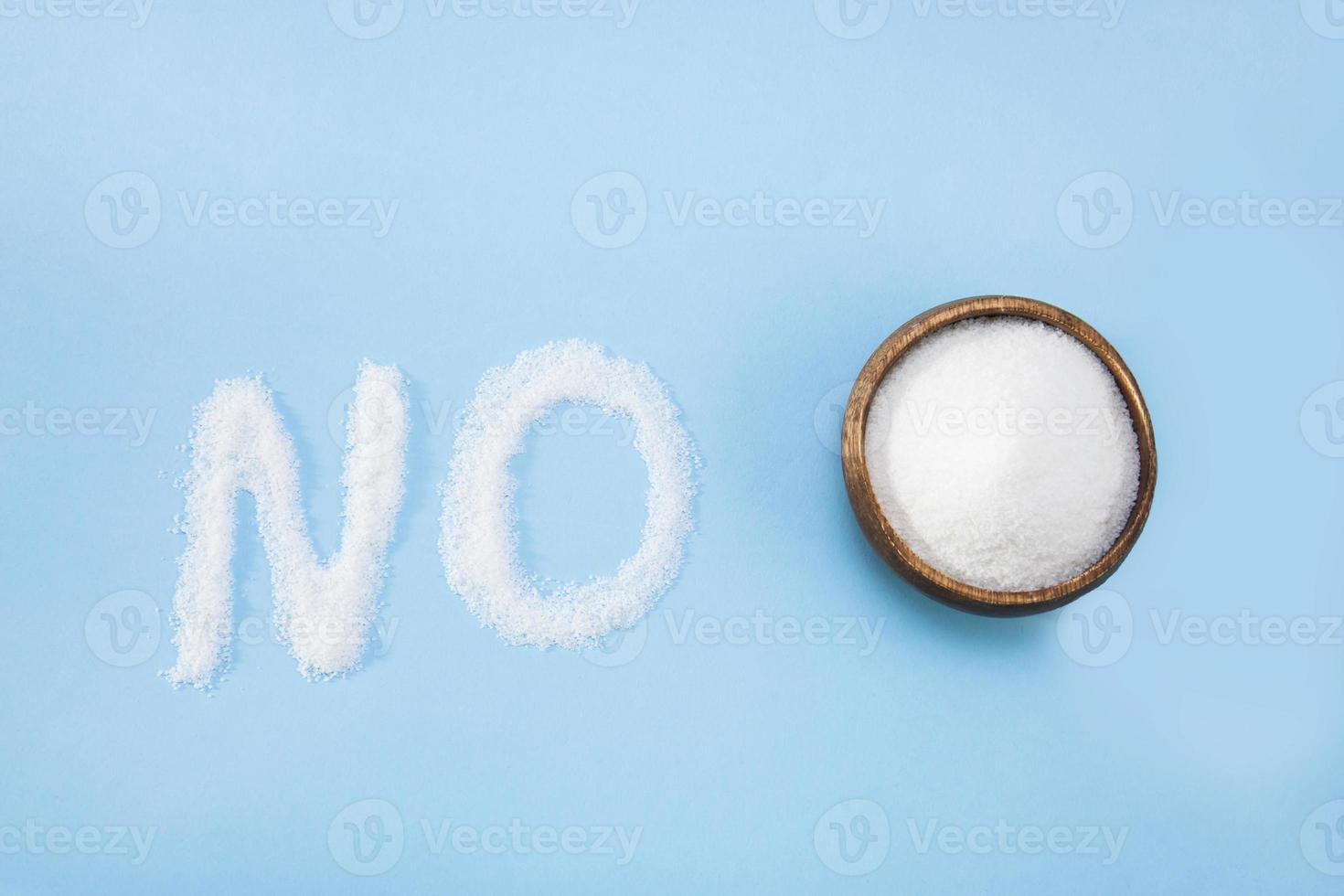 word no next to a cup of sugar on a blue background, proper nutrition photo