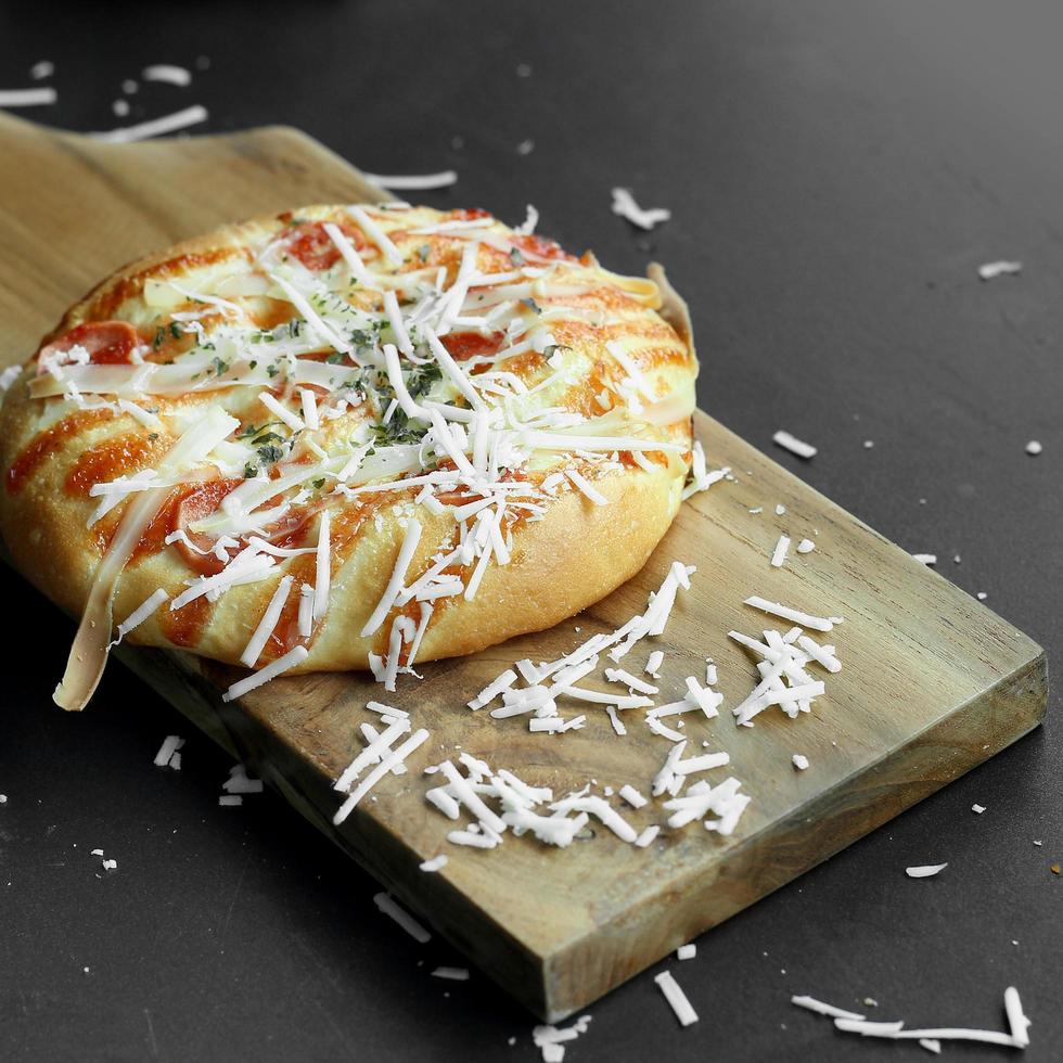 mini pizza topped with grated cheese and some meat photo