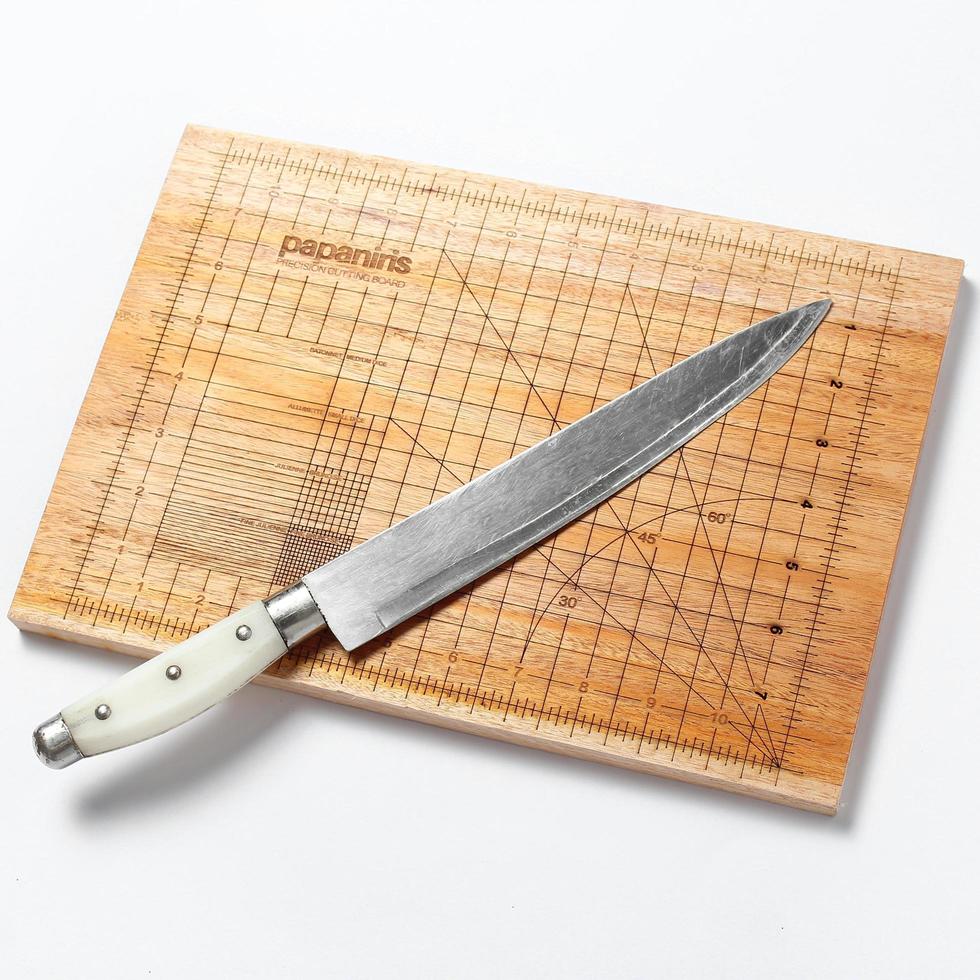 cutting board with a measuring tool and a knife on it photo