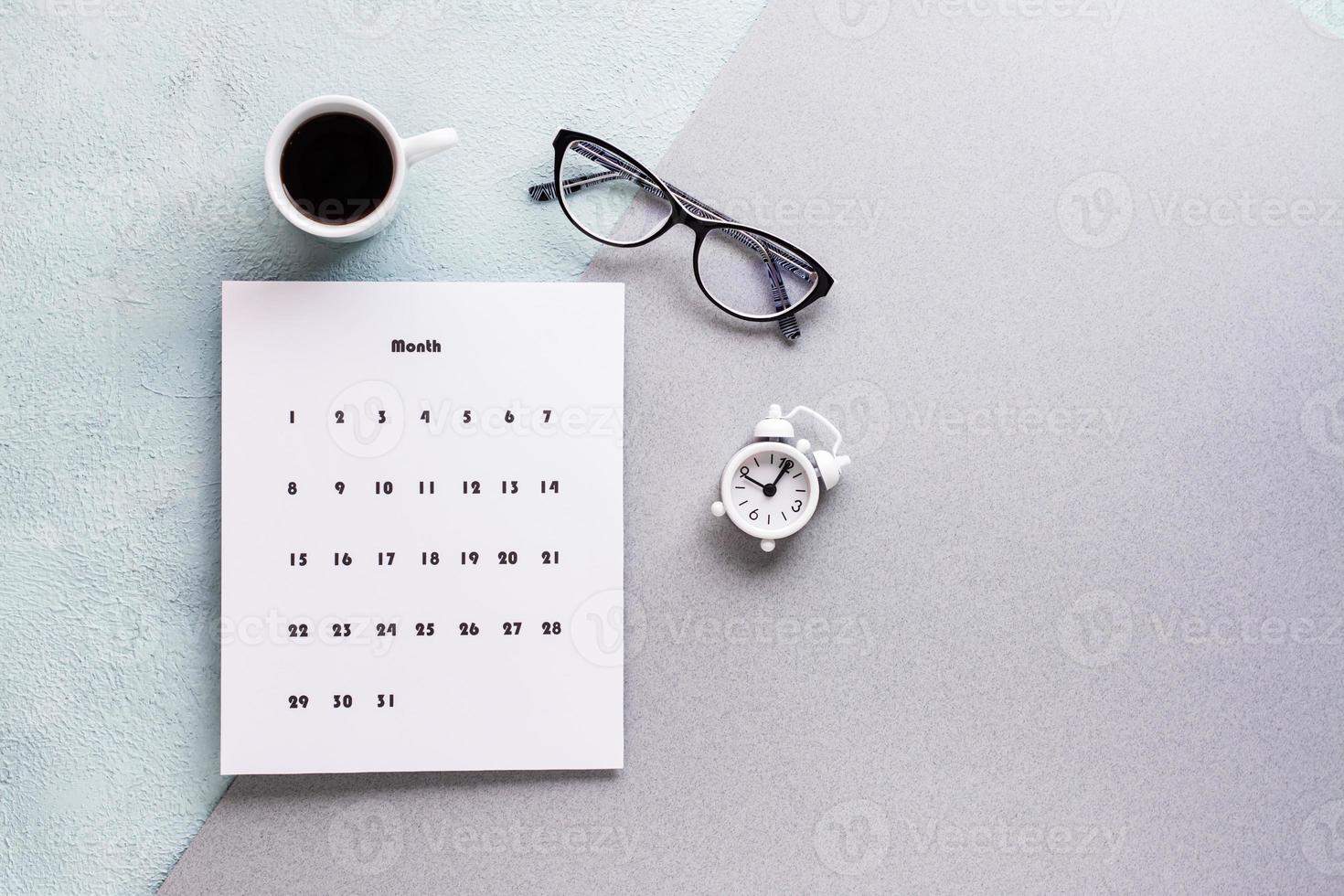 blanco sábana de mensual calendario, café taza, alarma reloj y lentes en texturizado antecedentes. hora planificación y organización foto