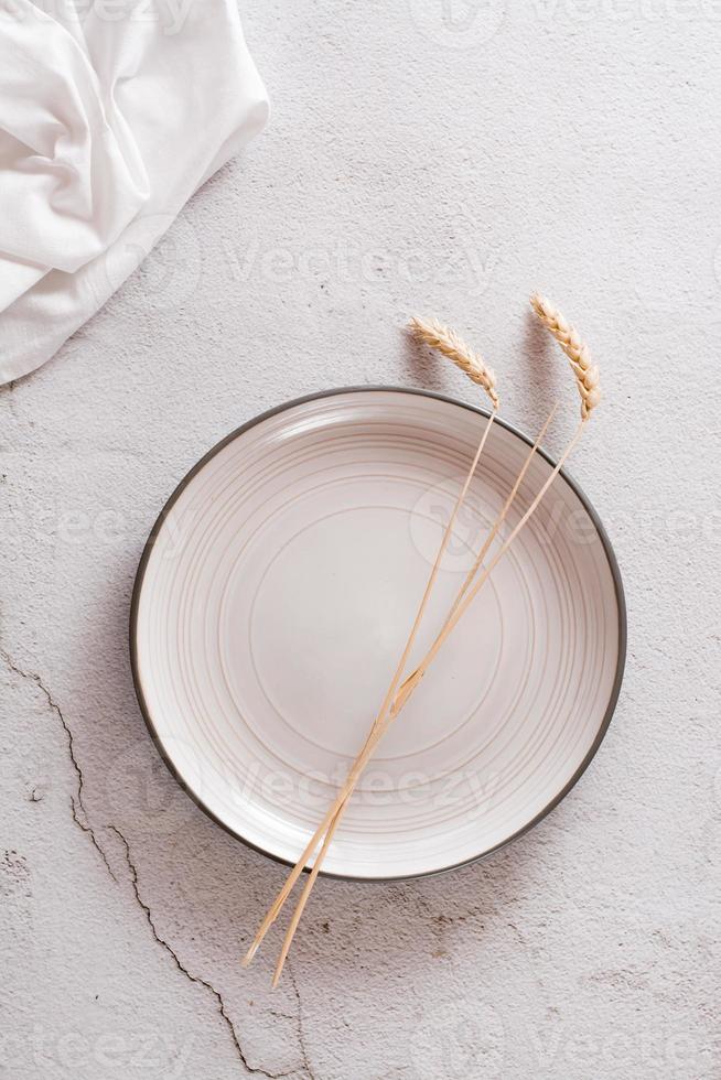 Eco mock up. Ears on an empty plate and cloth on a light concrete background. Top and vertical view. photo