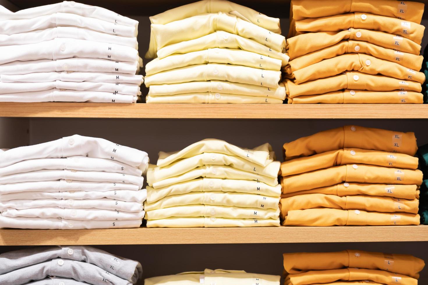 Stack of cotton colorful clothes on table in cloth store. photo