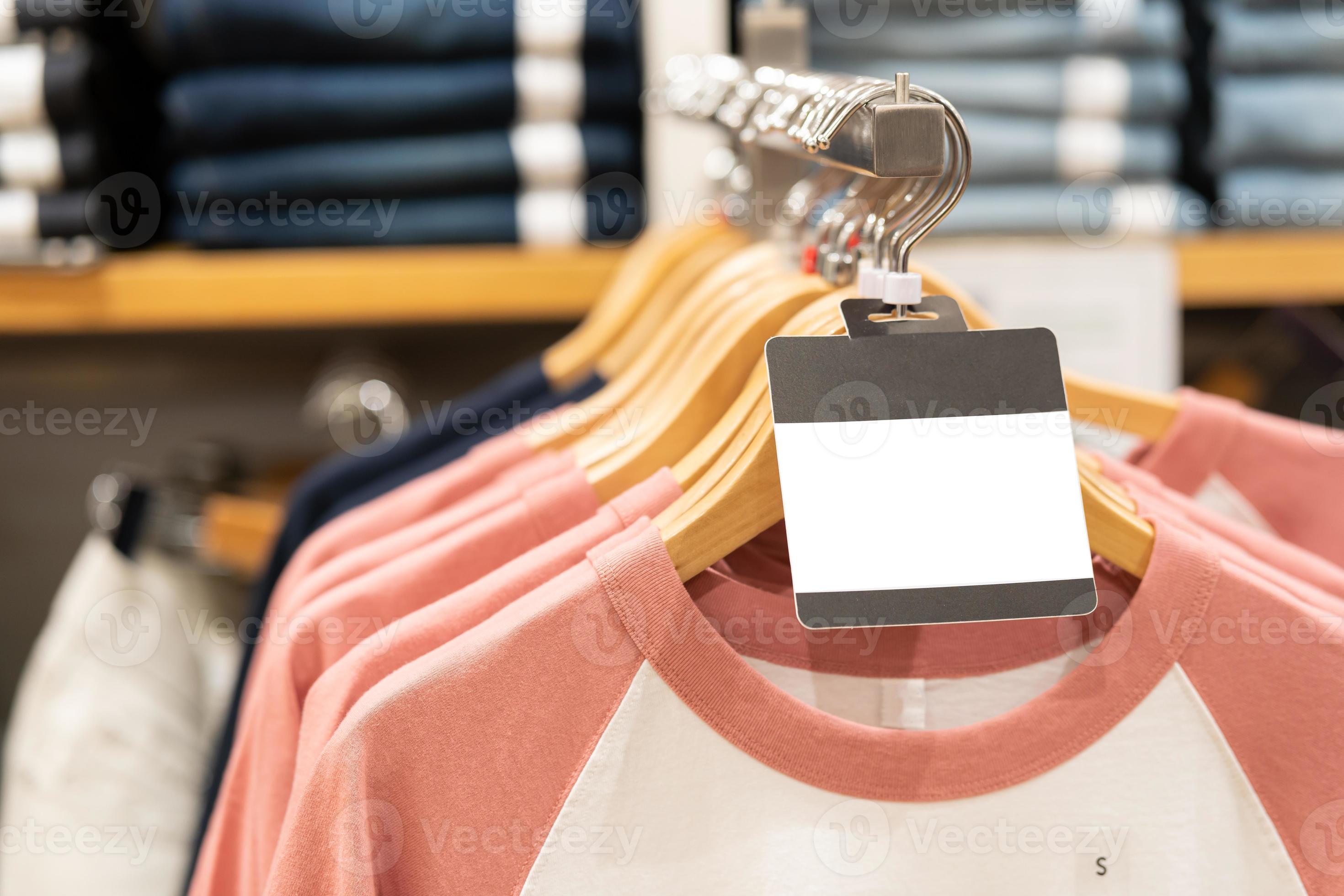 blank tag with Clothes hang on a shelf in a designer clothes store
