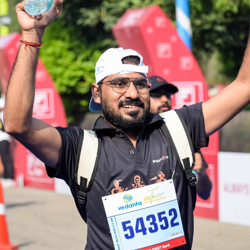 New Delhi, India - October 16 2022 - Vedanta Delhi Half Marathon race after covid in which marathon participants about to cross the finish line, Delhi Half Marathon 2022 photo