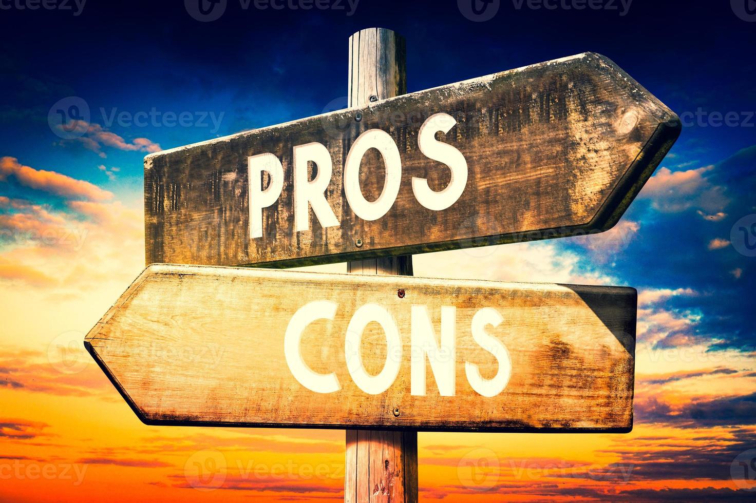 Pros, Cons - Wooden Signpost with Two Arrows, Sunset Sky in Background photo
