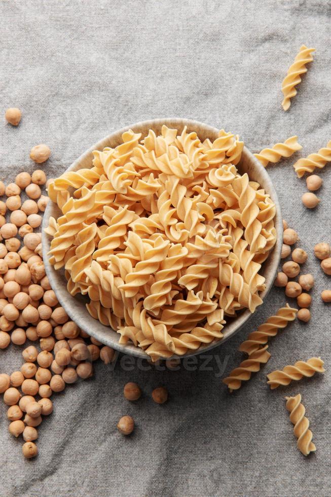 pasta fusilli de garbanzos sobre un fondo textil gris. foto