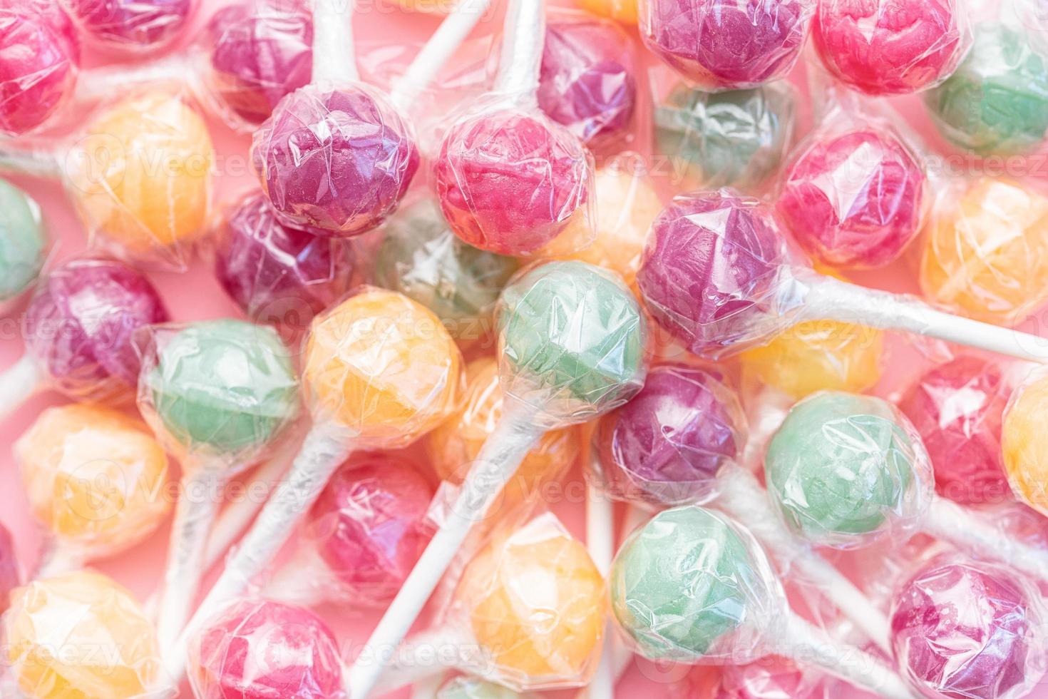 Sweet lollipops on pink background photo