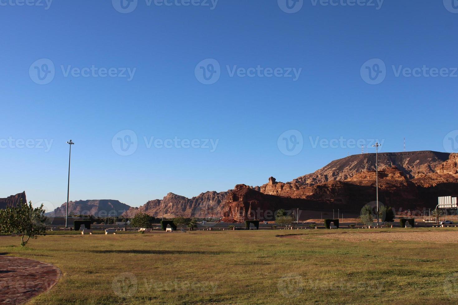 A beautiful daytime view of a winter park in Al Ula, Saudi Arabia. The park is surrounded by ancient hills. photo