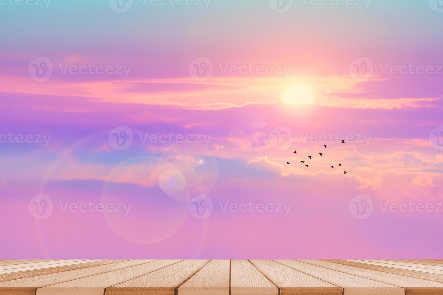 Empty wood table top and blur sunset colorful pastel sky and silhouette flying birds cloud background photo