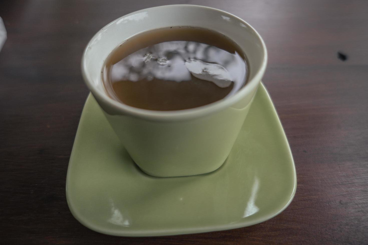 Close up photo of hot ginger traditional drink of Indonesia with green cup. The photo is suitable to use for drink background and foodies post content.