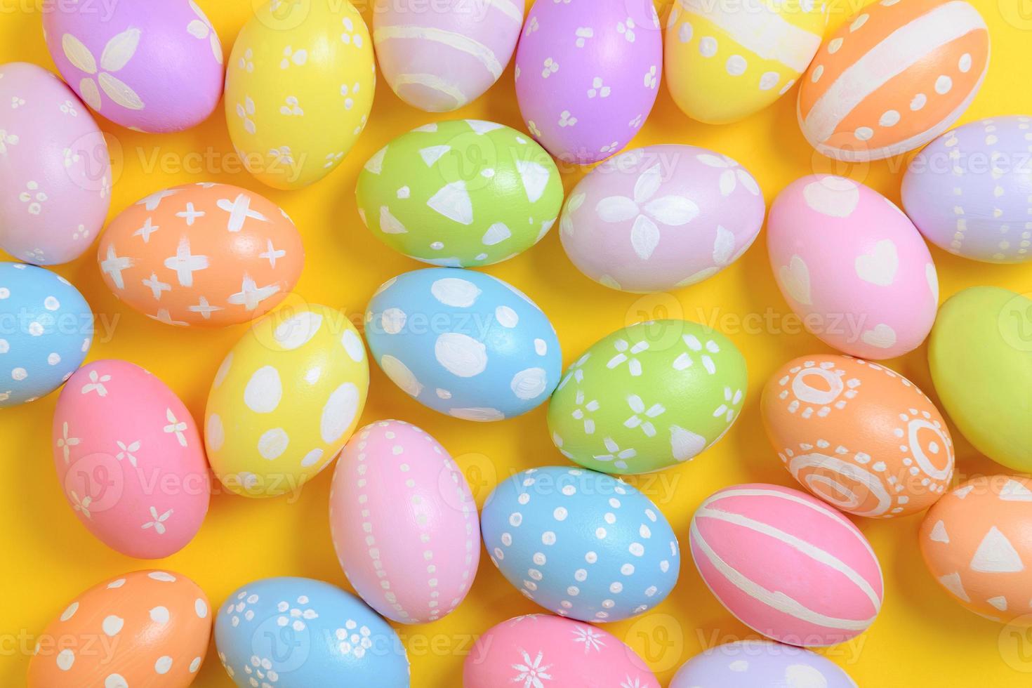 Happy easter holiday celebration concept. Group of painted colourful eggs decoration on a yellow background. Seasonal religion tradition design. Top view, flat lay, copy space. photo