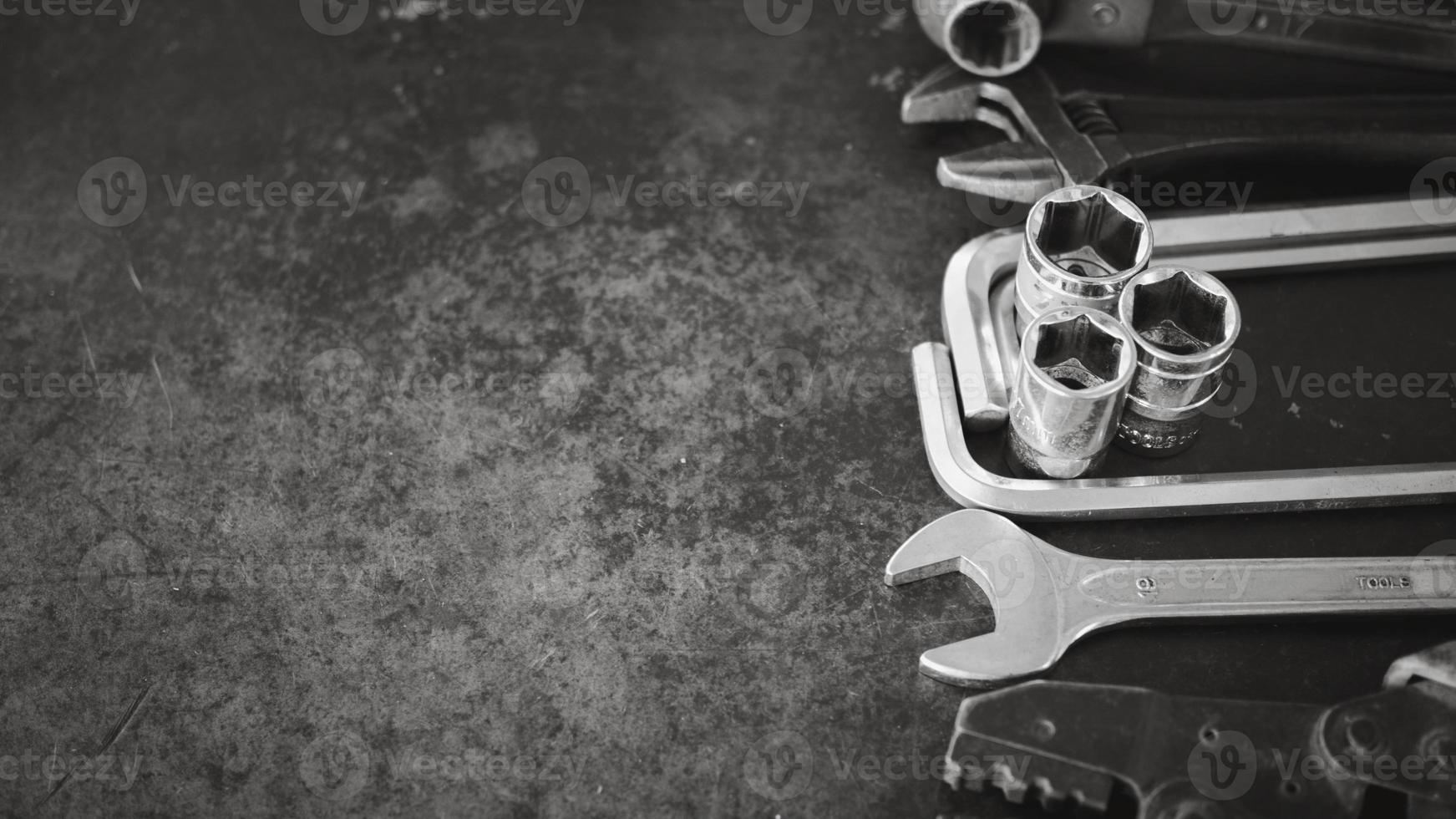 Hand tools consisting of wrenches, pliers, socket wrenches, laid out on old steel plate background. photo