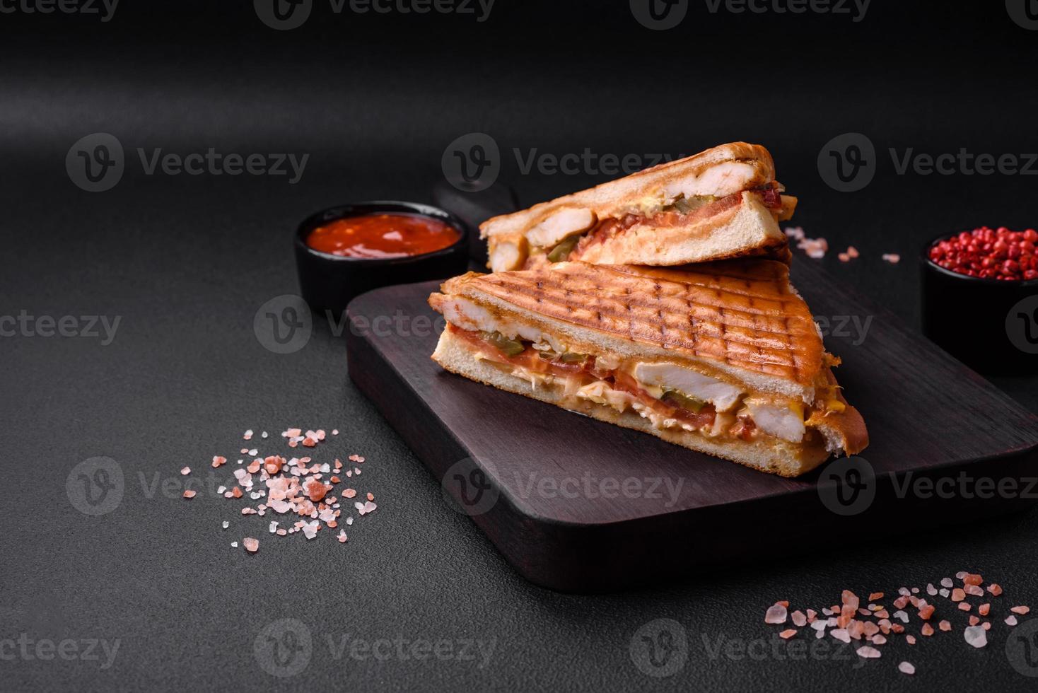 Delicious crispy sandwich with chicken breast, tomatoes, ketchup and spices photo