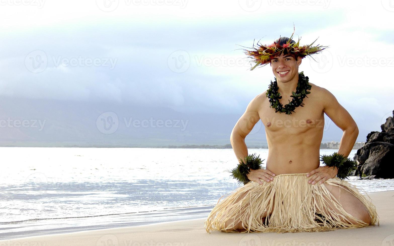 Male Hula Dancer ends a performance on the sand with a big smile. photo
