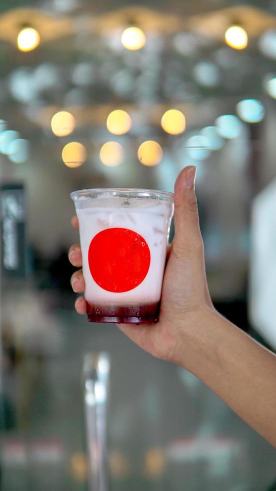 Strawberry cocktail in hand on bokeh background photo