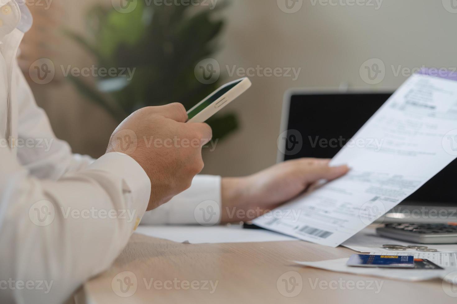 Cost, budget asian young man calculate expense, spending and check from invoice, use smartphone, mobile phone pay payment internet online of credit card at home. Technology of finance, financial. photo