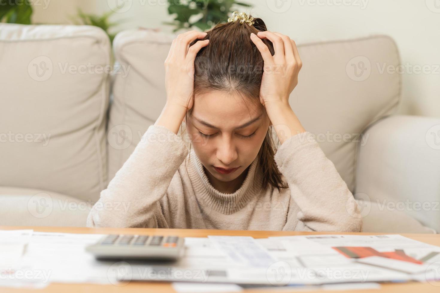 financiero deber asiático joven mujer, niña sentado sufrir, estresado y confuso por calcular gastos desde factura o factura, tener No dinero a pagar, hipoteca o préstamo. deuda, bancarrota o bancarrota concepto. foto