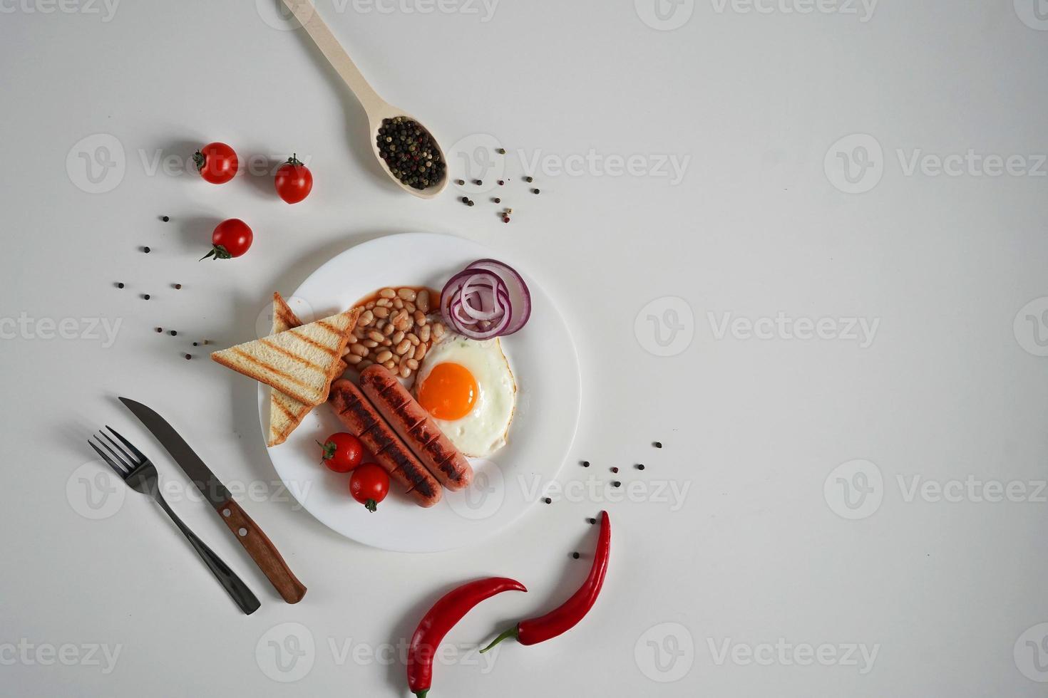 English Breakfast - fried egg, tomatoes and sausage on White Background. Top view. Copy space for text photo