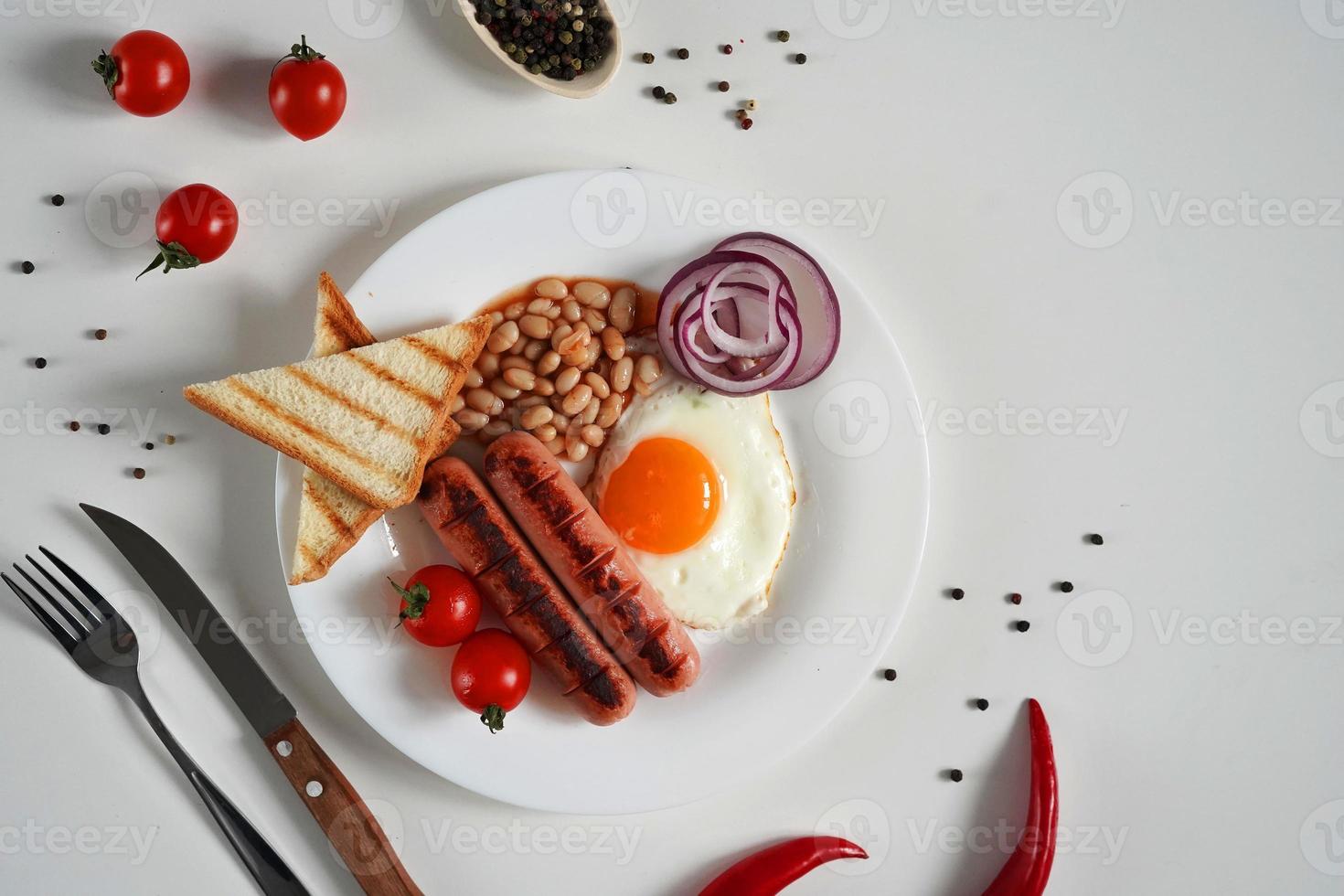 English Breakfast - fried egg, tomatoes and sausage on White Background. Top view. Copy space for text photo