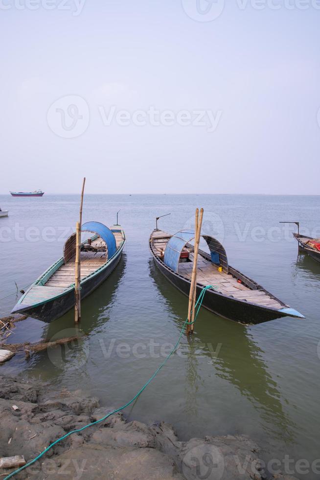 landscape view of Some wooden fishing boats on the shore of the Padma river in Bangladesh photo