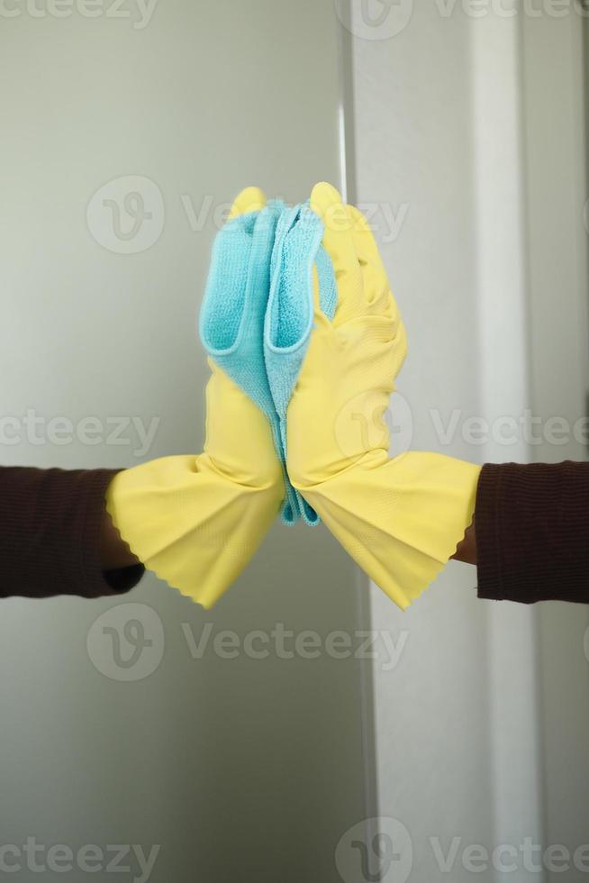 close up of person hand in gloves cleaning window glass photo