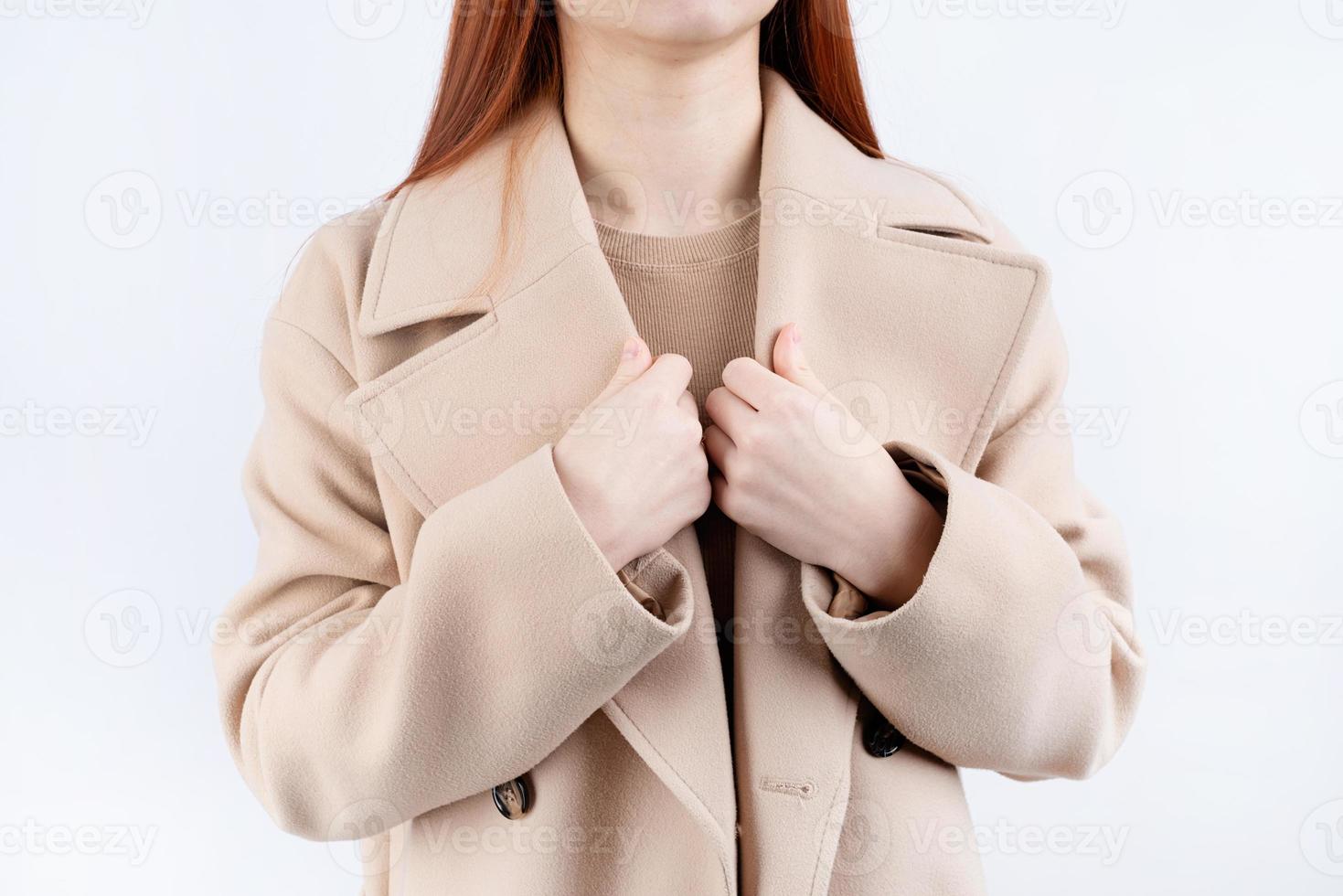 closeup woman wearing beige pastel coat in white background photo