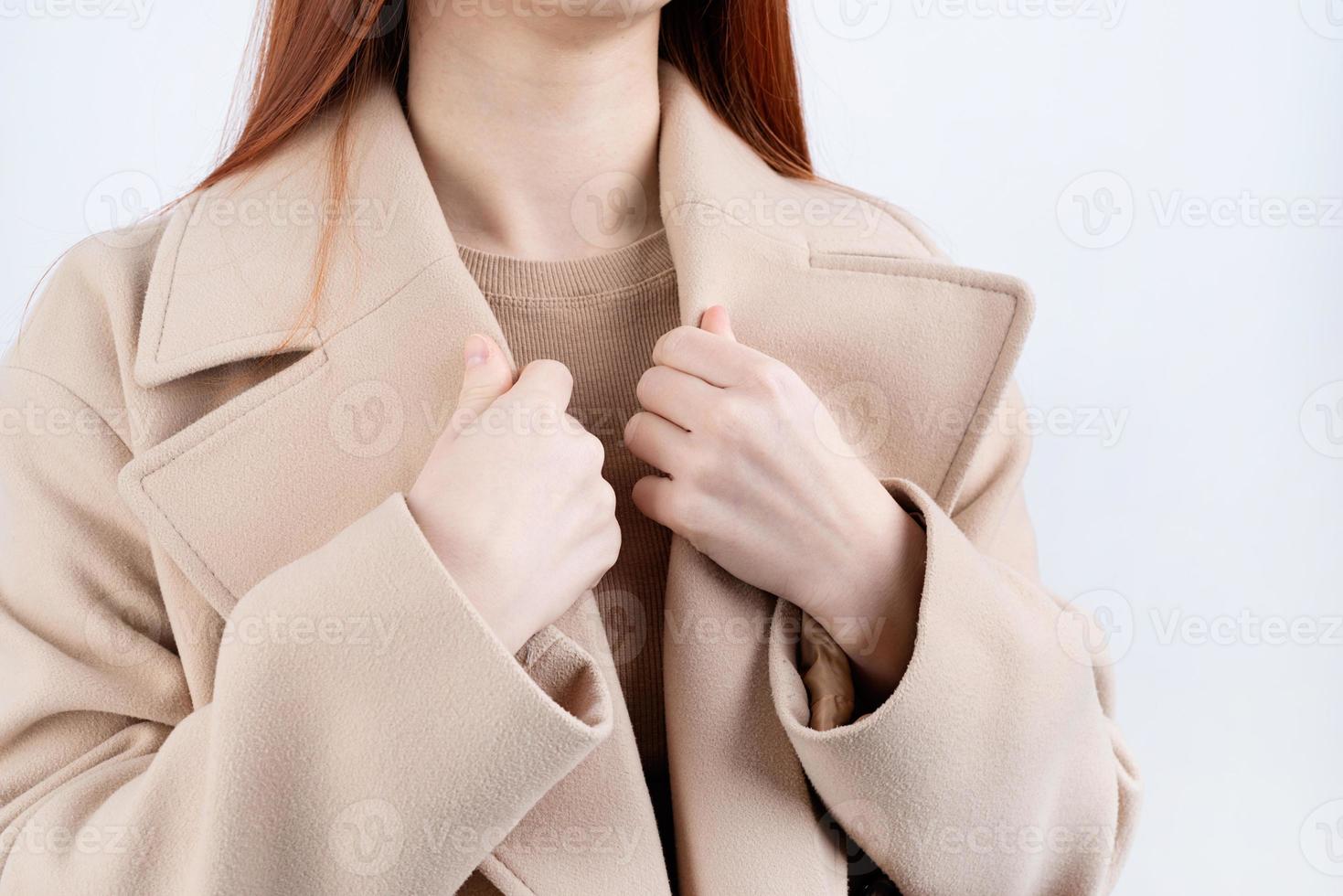 closeup woman wearing beige pastel coat in white background photo