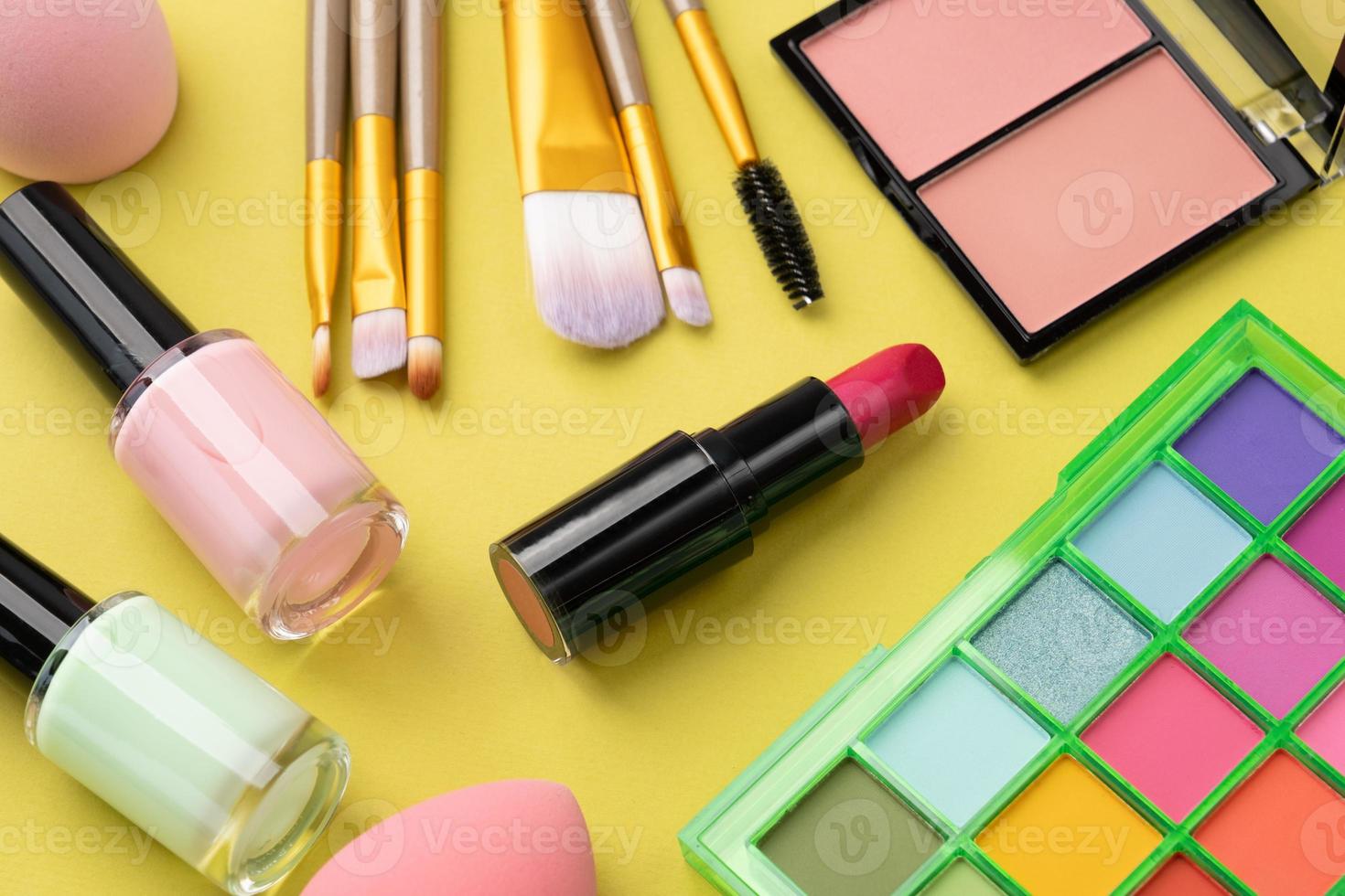 Bright summer eyeshadow palette and makeup products and lipstick for mockup on green background photo