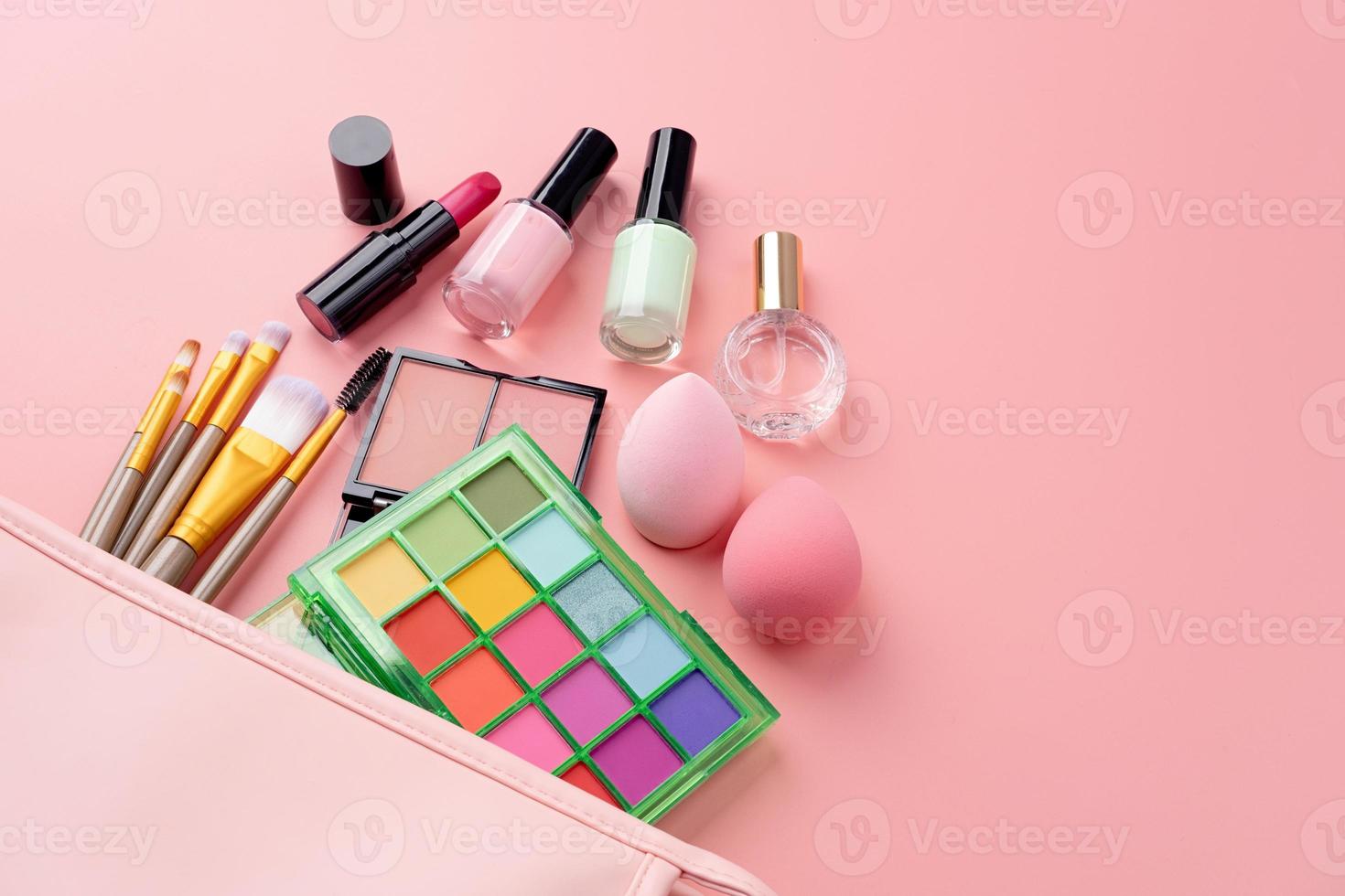 brillante verano sombra paleta y maquillaje productos en rosado cosmético bolso en rosado antecedentes foto