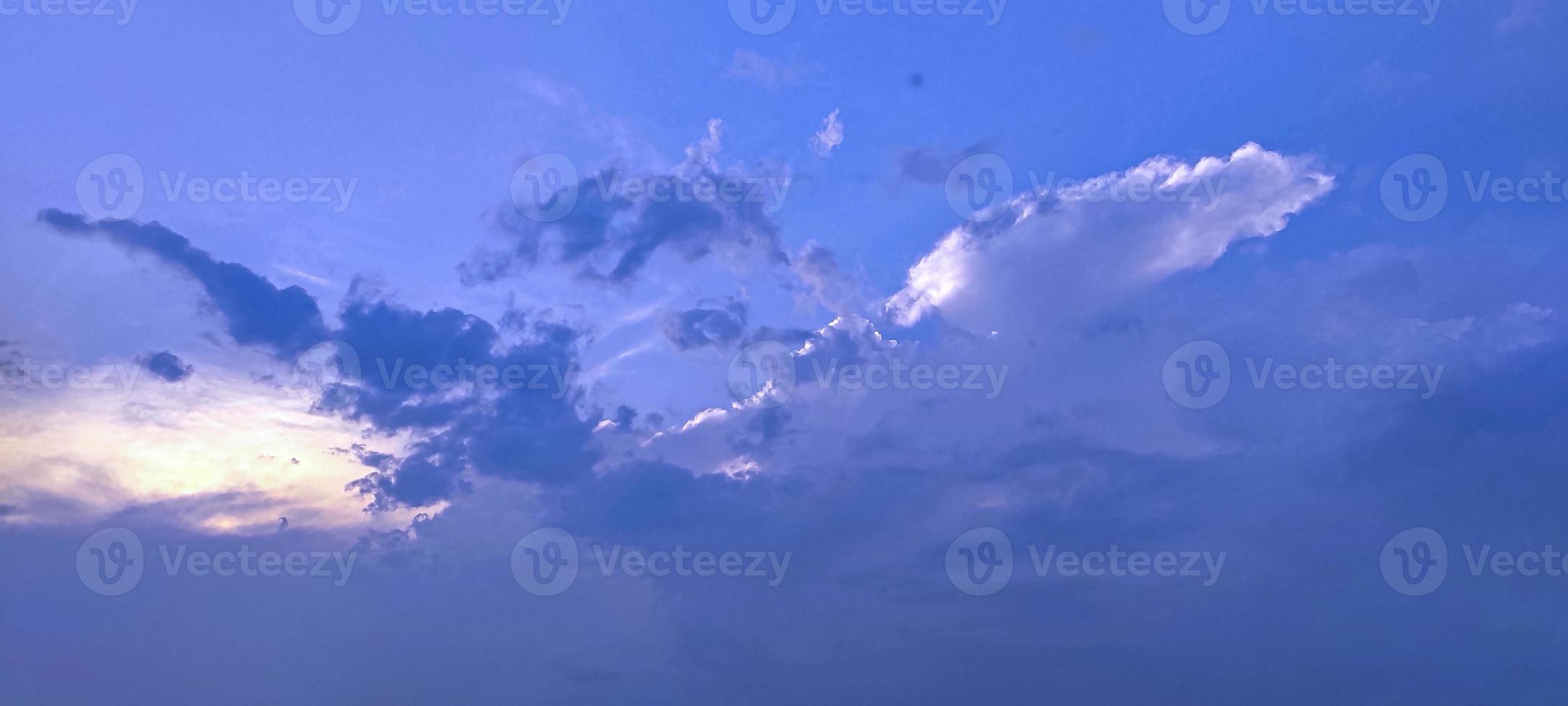 Clouds in the sky with the sun setting blue sky white and black cloud photo