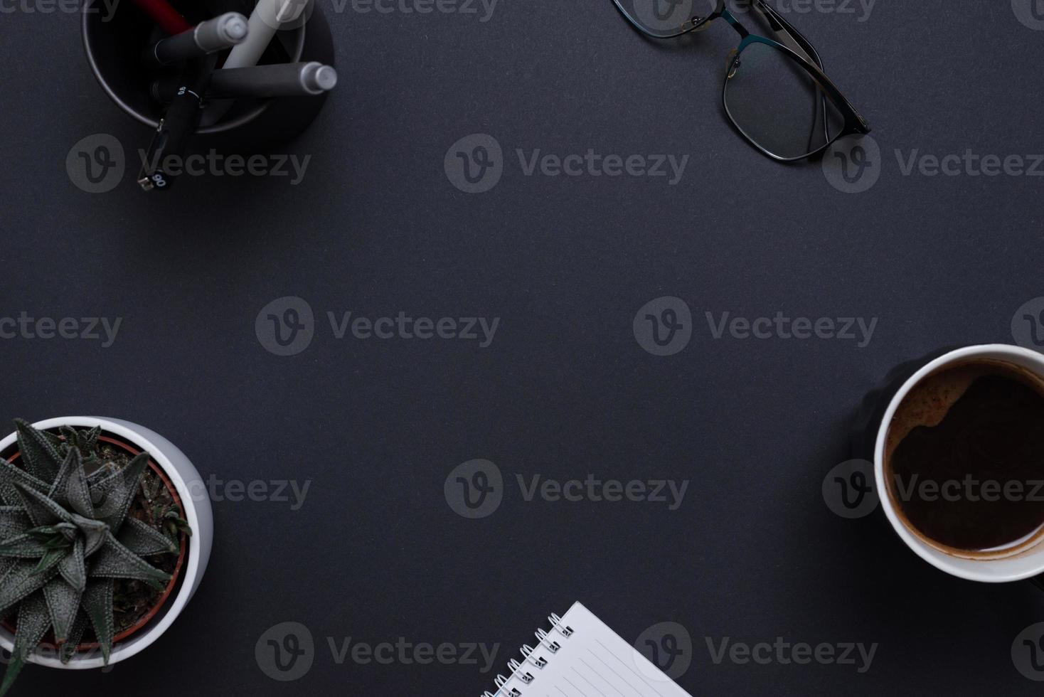 Top view, flat lay business composition with copy space in the middle on black desk. For logo or copy presentation photo