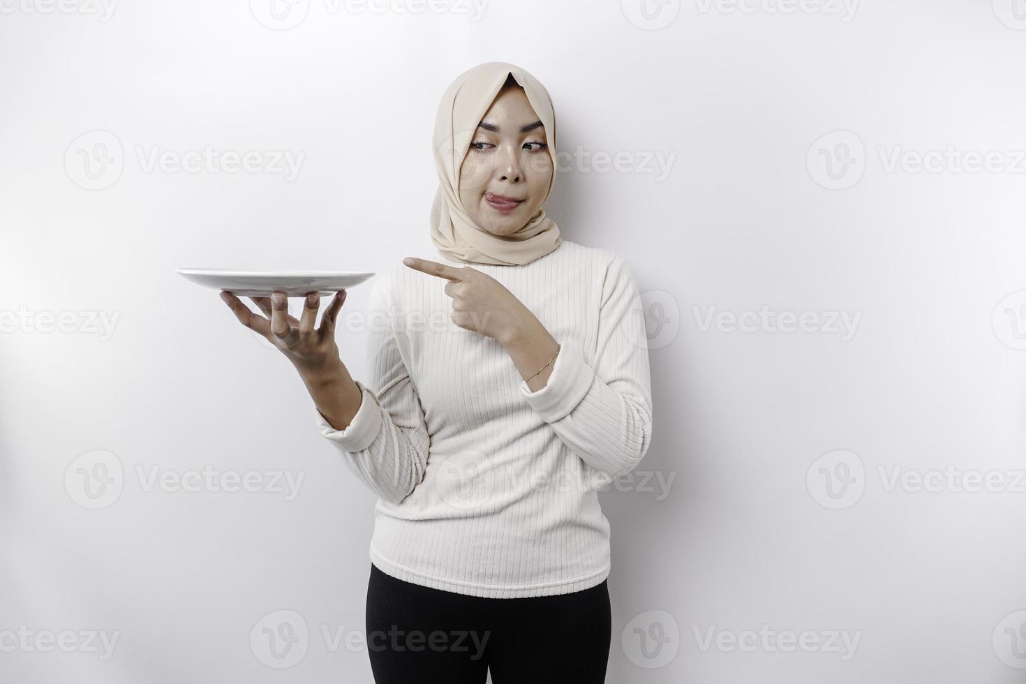 un sonriente asiático musulmán mujer es rápido y hambriento y participación y señalando a un plato foto