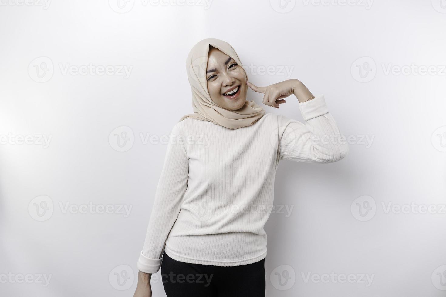 un retrato de un linda asiático musulmán mujer vistiendo un Pañuelo, y sensación emocionado y aislado por un blanco antecedentes foto