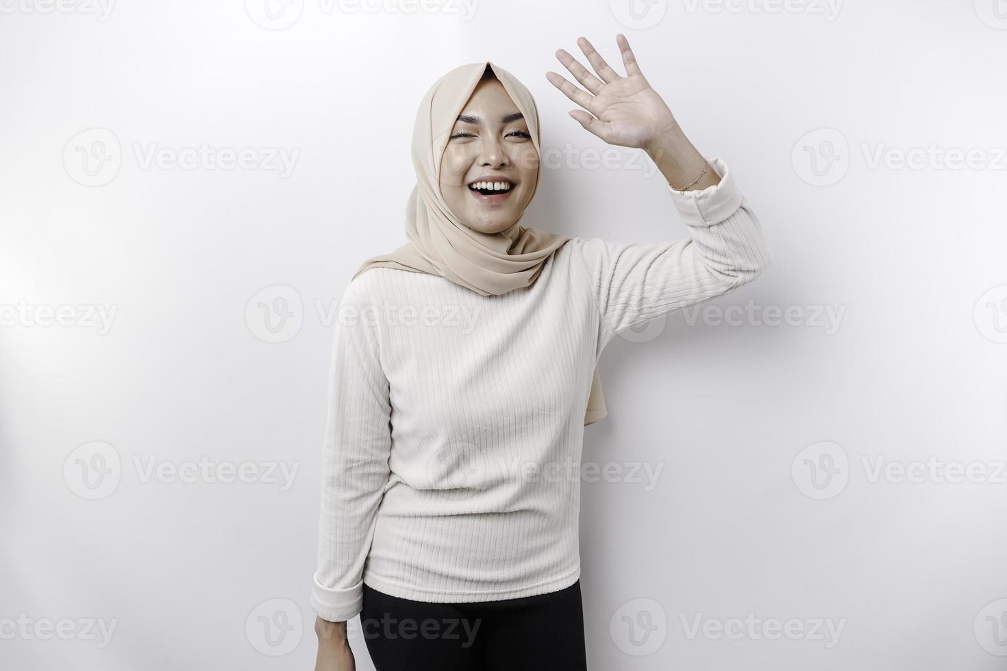 retrato de un joven hermosa asiático musulmán mujer vistiendo un Pañuelo gesticulando eid Mubarak saludo foto