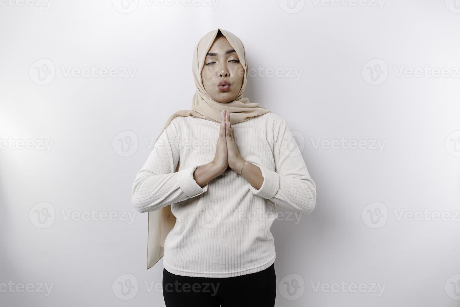 asiático musulmán mujer practicando yoga y medita actitud con cerrado ojos aislado por blanco antecedentes foto