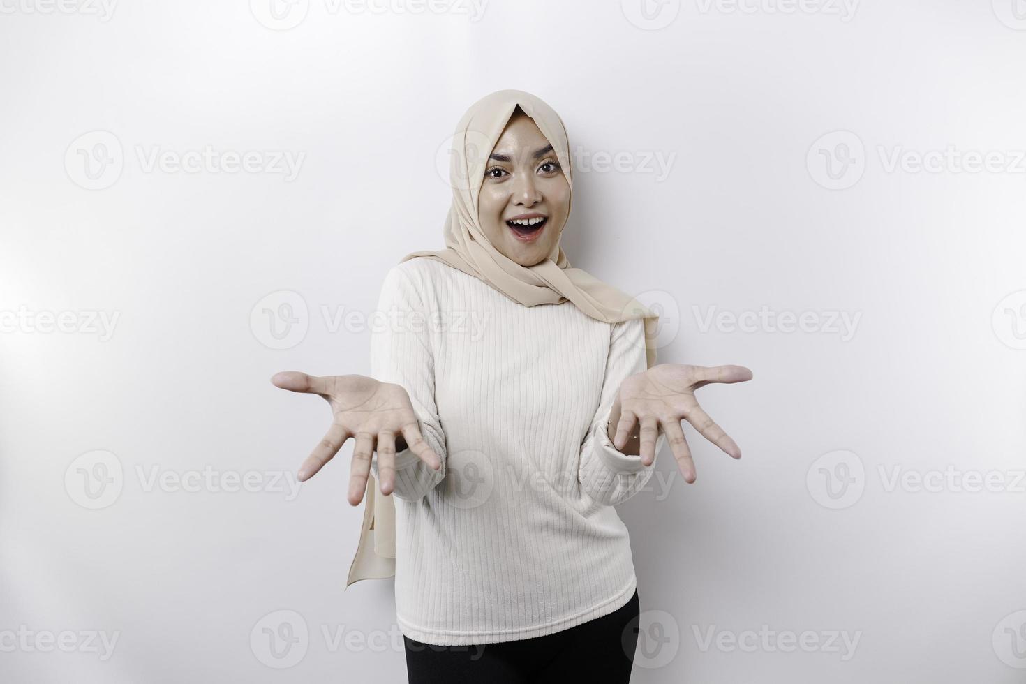 retrato de un joven hermosa asiático musulmán mujer vistiendo un Pañuelo gesticulando eid Mubarak saludo foto