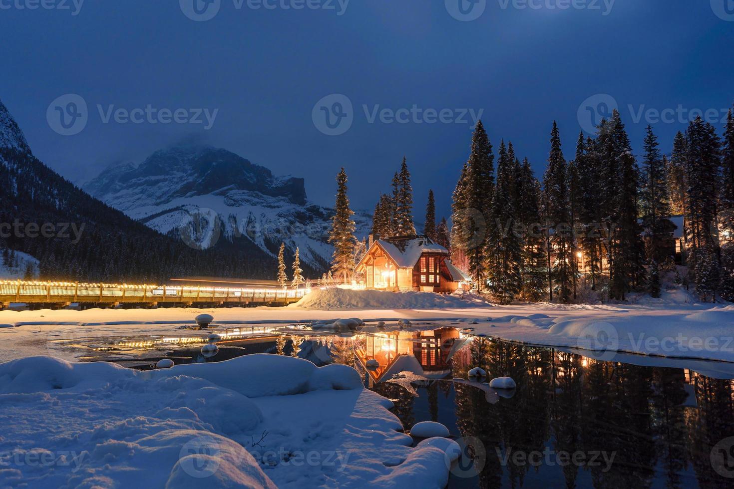 Emerald Lake with wooden lodge glowing in snowy pine forest on winter at Yoho national park photo