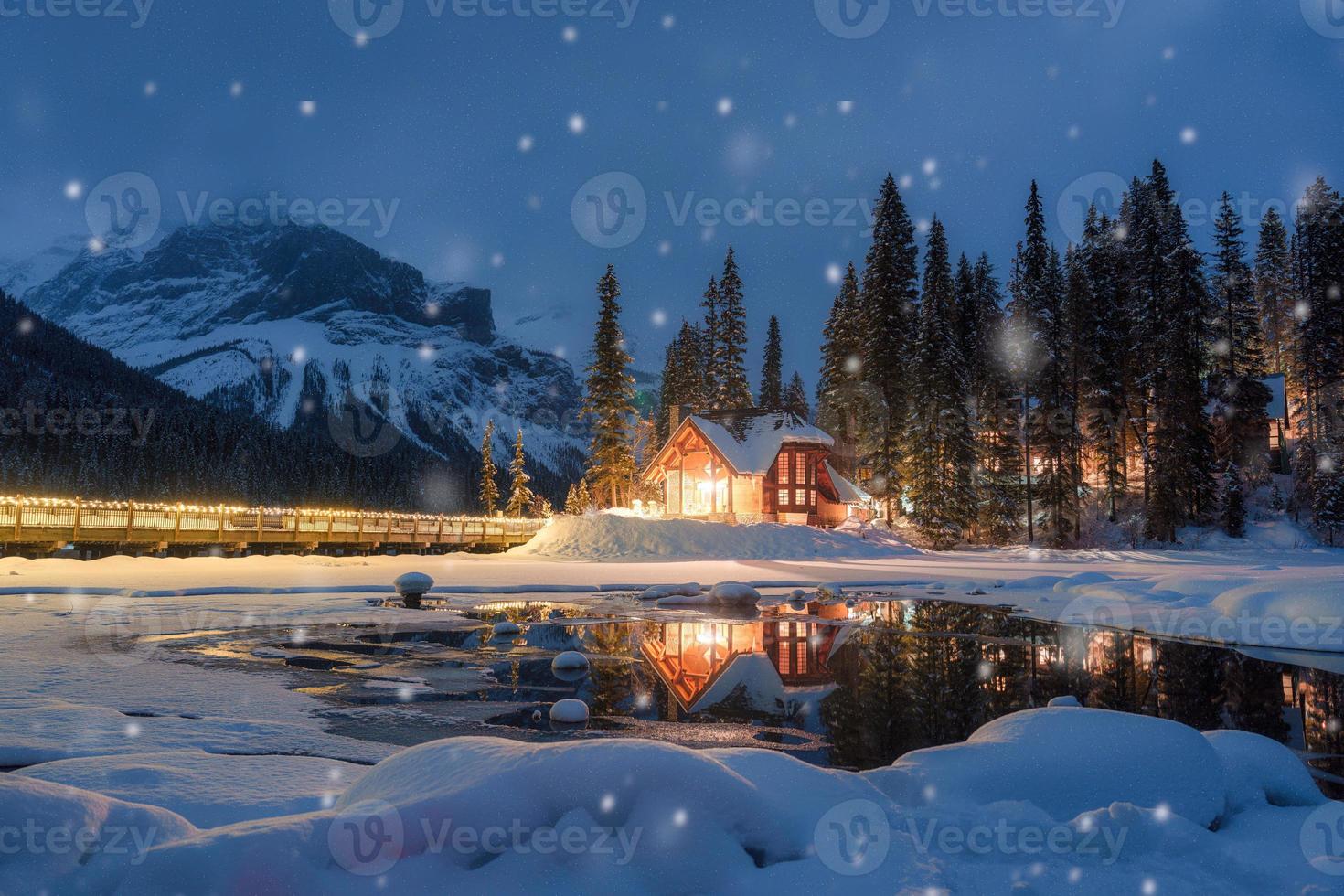 Emerald Lake with wooden lodge glowing and snowfall in pine forest on winter at Yoho national park photo